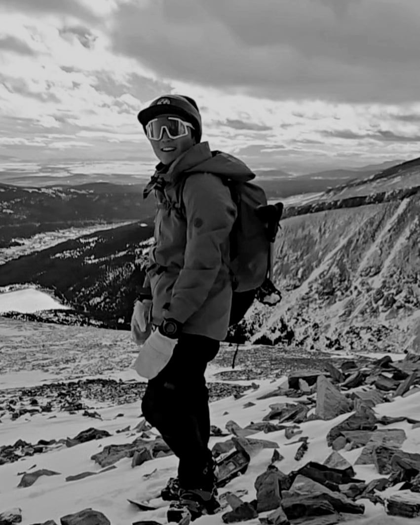 Sky Yoo on a snow-covered mountain ridge, in goggles and a shell jacket